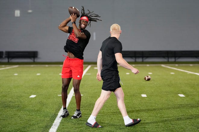 Jul 21, 2023; Columbus, Ohio, USA;  Ohio State Buckeyes wide receiver Marvin Harrison Jr. laughs with Reis Stocksdale as he catches balls from a robotic throwing machine during a summer workout at the Woody Hayes Athletic Center prior to the start of fall camp.
