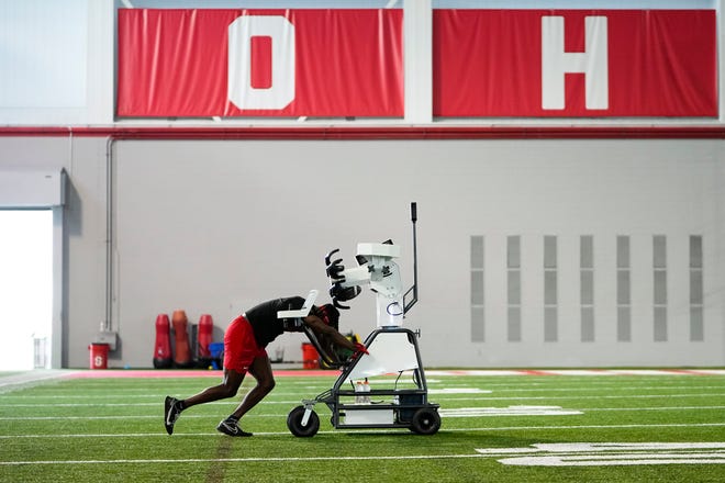Jul 21, 2023; Columbus, Ohio, USA;  Ohio State Buckeyes wide receiver Marvin Harrison Jr. pushes a robotic throwing machine onto the field at the Woody Hayes Athletic Center during a summer workout prior to the start of fall camp.