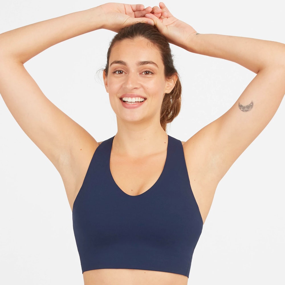 Model wearing Spanx Longline Medium Impact Sports Bra in navy