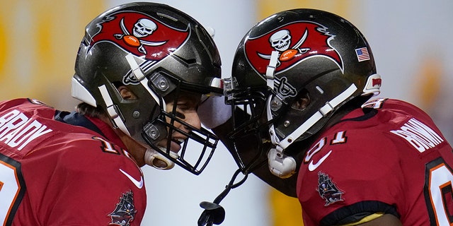 Tampa Bay Buccaneers quarterback Tom Brady (12) and wide receiver Antonio Brown (81) celebrate a touchdown pass during the first half of an NFL wild-card playoff football game against the Washington Football Team, Saturday, Jan. 9, 2021, in Landover, Md.